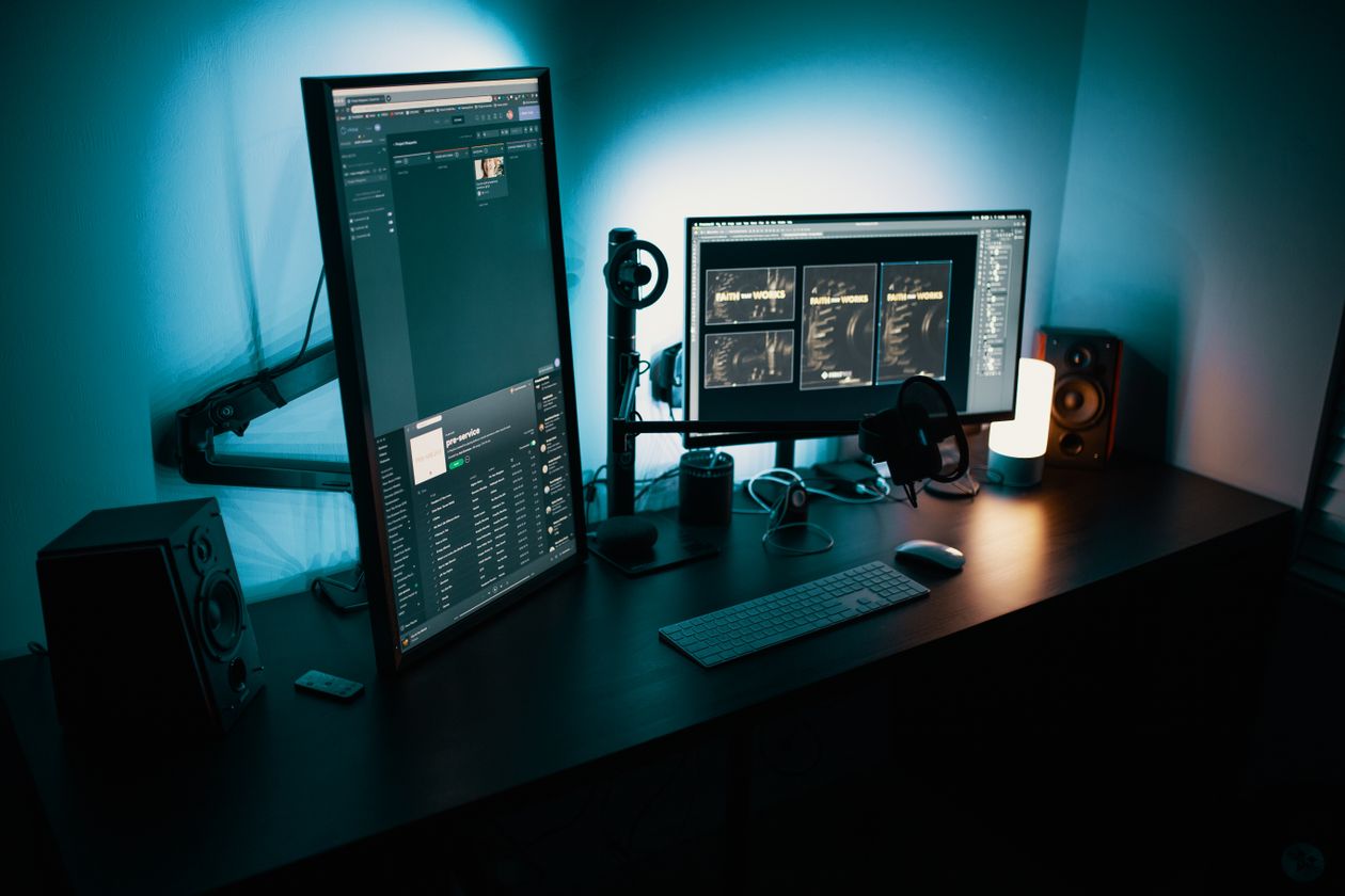 Dual-monitor creator workstation running image editing software in a dark studio